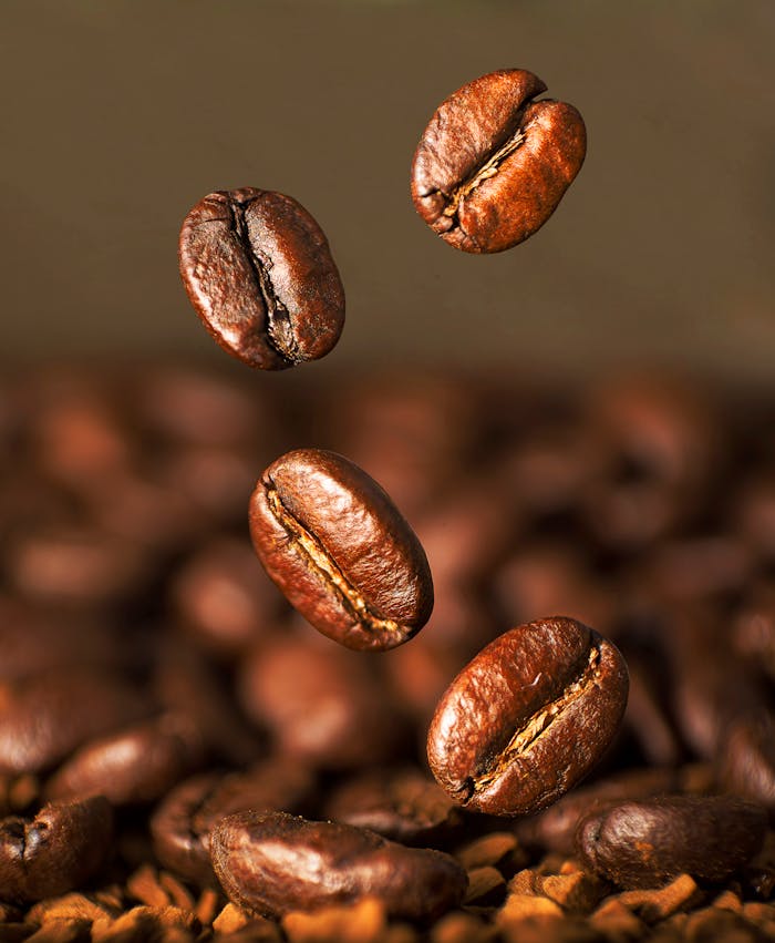 A mesmerizing close-up of roasted coffee beans suspended in mid-air, capturing the essence of their aromatic allure.